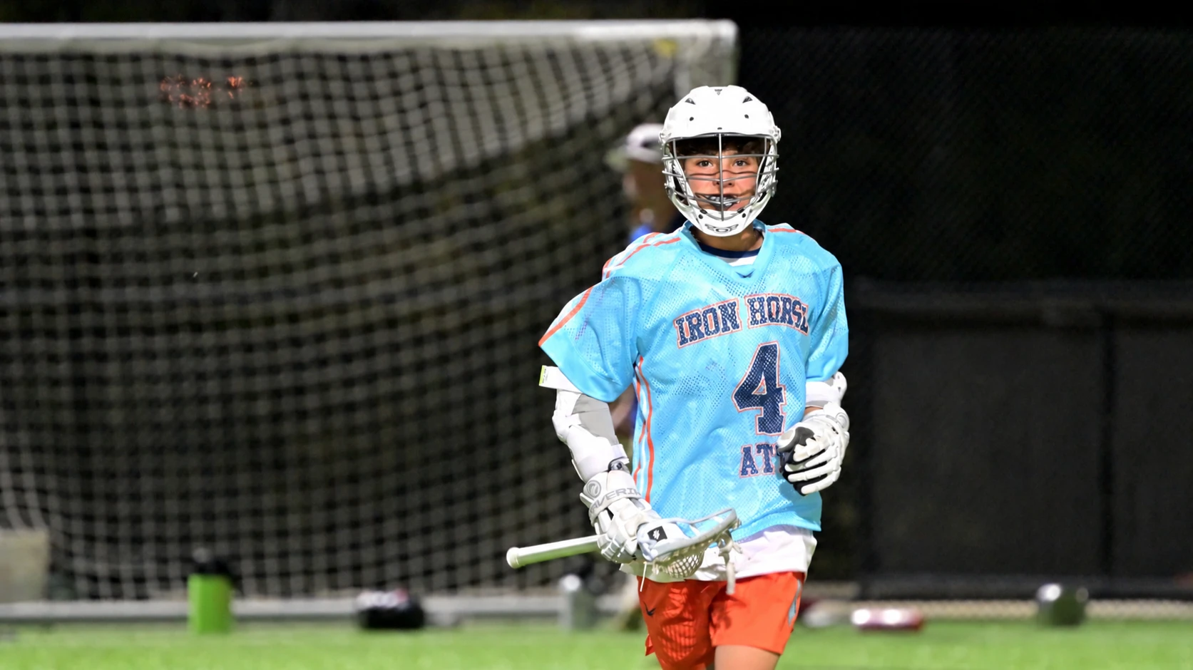 ADVNC ATX player carrying the ball in front of the goal under the lights